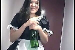 Young Asian girl dressed as a maid indulges herself with a bottle of champagne on camera for you